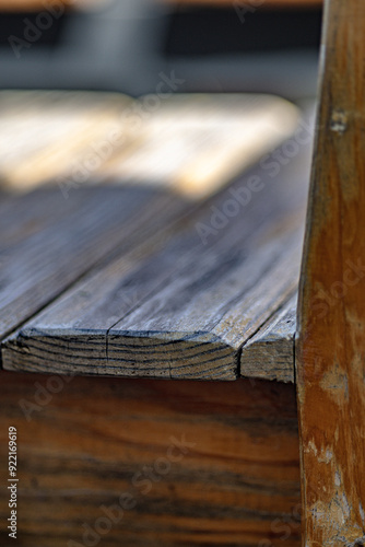 A wooden bench with a wooden floor. The bench is old and has a worn look to it