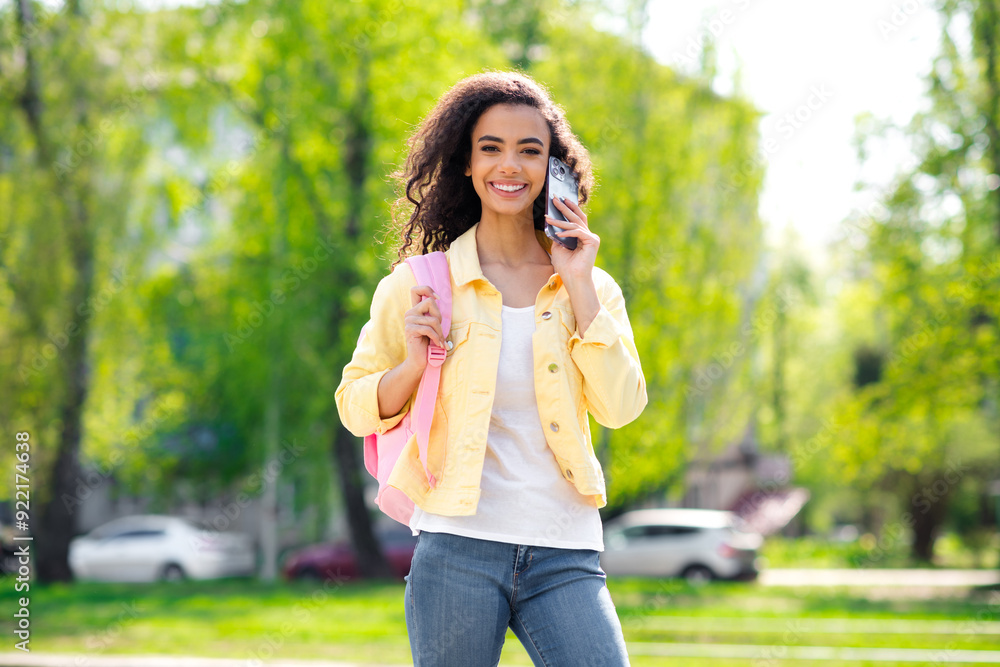 Portrait of attractive wavy hair cheerful girl enjoy good weather talk phone pink blackpack wear yellow jacket having fun outside outdoors Portrait of attractive wavy hair cheerful girl enjoy good weather talk phone pink blackpack wear yellow jacket having fun outside outdoors