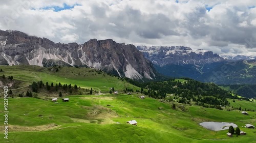 Aerial view of the rocky peaks of the Seceda Mountain touching the clouds in the Dolomites, Italy