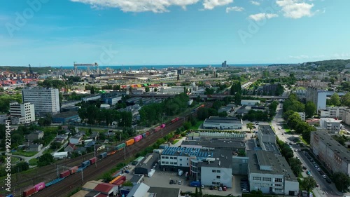 Wallpaper Mural Aerial view of a coastal industrial area featuring a port, railway tracks with colorful cargo trains, and urban buildings. Mix of industrial and residential areas - Gdynia, Poland Torontodigital.ca