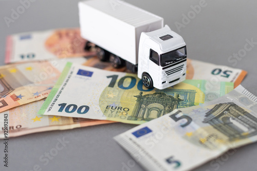 Foto Toy car truck with money isolated on white background