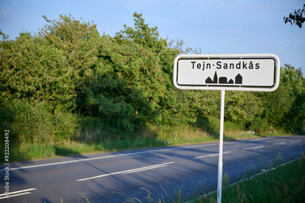 Roadside Sign for Tejn-Sandkås Village along a Tree-Lined Road in the Countryside on the Danish island of Bornholm Roadside Sign for Tejn-Sandkås Village along a Tree-Lined Road in the Countryside on the Danish island of Bornholm