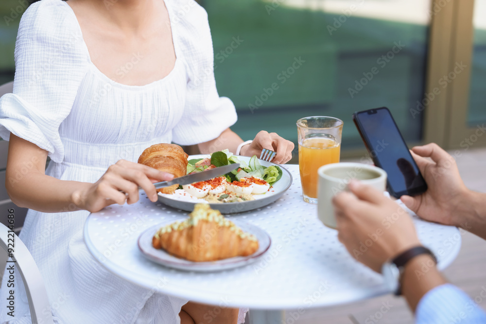 Couple having tasty breakfast in outdoor cafe, closeup Couple having tasty breakfast in outdoor cafe, closeup