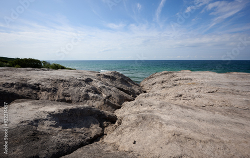 Rocky Coastal View with Expansive Ocean Horizon under a Clear Blue Sky with Light Clouds at "Kultippen" on the danish island of Bornholm