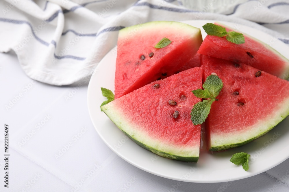 Fresh watermelon slices with mint leaves on white tiled table, closeup. Space for text Fresh watermelon slices with mint leaves on white tiled table, closeup. Space for text