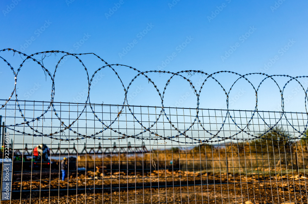 Sharp razor wire on fence around construction site Sharp razor wire on fence around construction site