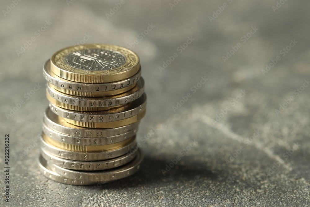 Stacked euro coins on grey table, space for text Stacked euro coins on grey table, space for text