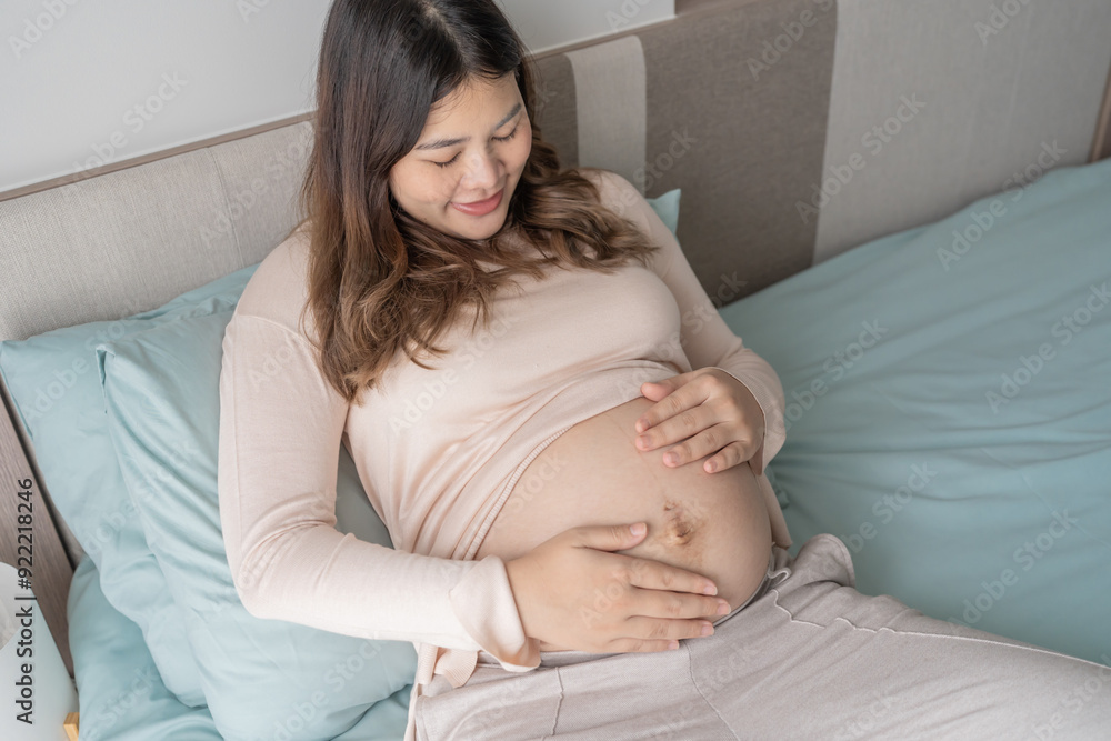 Pregnant asian woman holds hands on belly touching her baby caring about her health Beautiful happy pregnant woman tender mood photo of pregnancy Pregnant asian woman holds hands on belly touching her baby caring about her health Beautiful happy pregnant woman tender mood photo of pregnancy