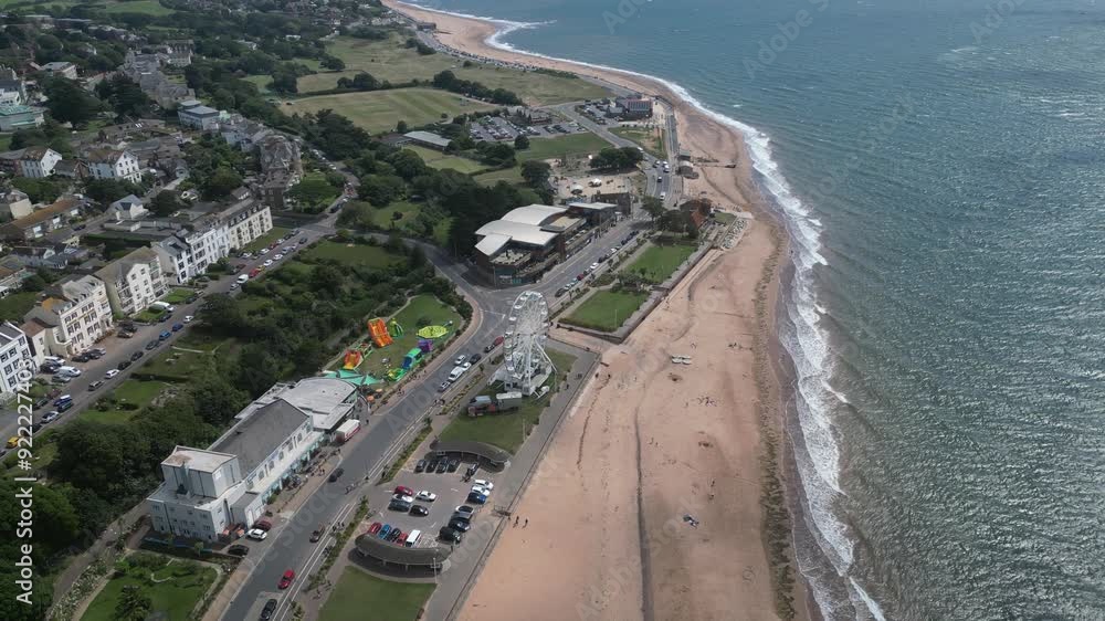 Exmouth, East Devon, England: DRONE VIEWS: Exmouth beach, rolling waves and seafront ferris wheel. The Jurassic Coast begins at Exmouth and is a UNESCO World Heritage Site. Exmouth, East Devon, England: DRONE VIEWS: Exmouth beach, rolling waves and seafront ferris wheel. The Jurassic Coast begins at Exmouth and is a UNESCO World Heritage Site.