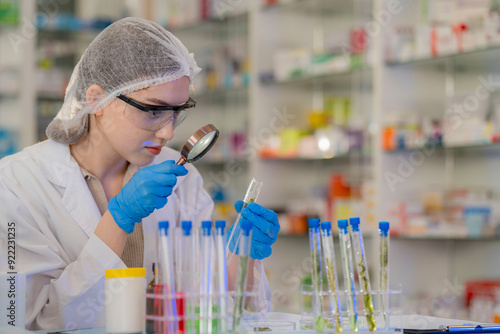 Scientists prepare for the experiment by wearing latex gloves. An experimenter arranges experimental equipment on a table with test tubes and chemicals for making drugs and biochemical for human. photo