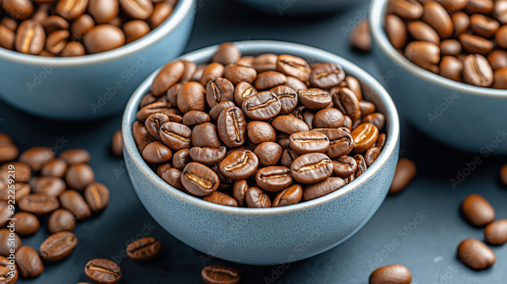Close-up of roasted coffee beans in blue ceramic bowls on a dark background. Close-up of roasted coffee beans in blue ceramic bowls on a dark background.