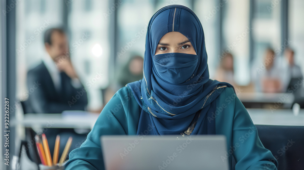 Woman in burqa working at office desk. Woman in burqa working at office desk.