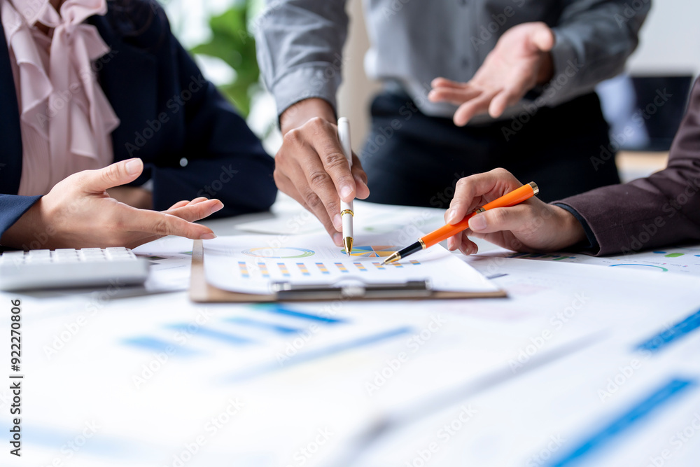 Business team analyzing financial charts and graphs discussing new strategy Business team analyzing financial charts and graphs discussing new strategy