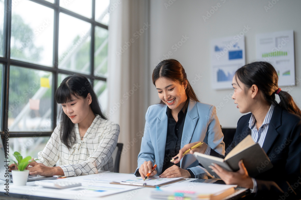 Three young asian businesswomen working together on a new project in office meeting room Three young asian businesswomen working together on a new project in office meeting room