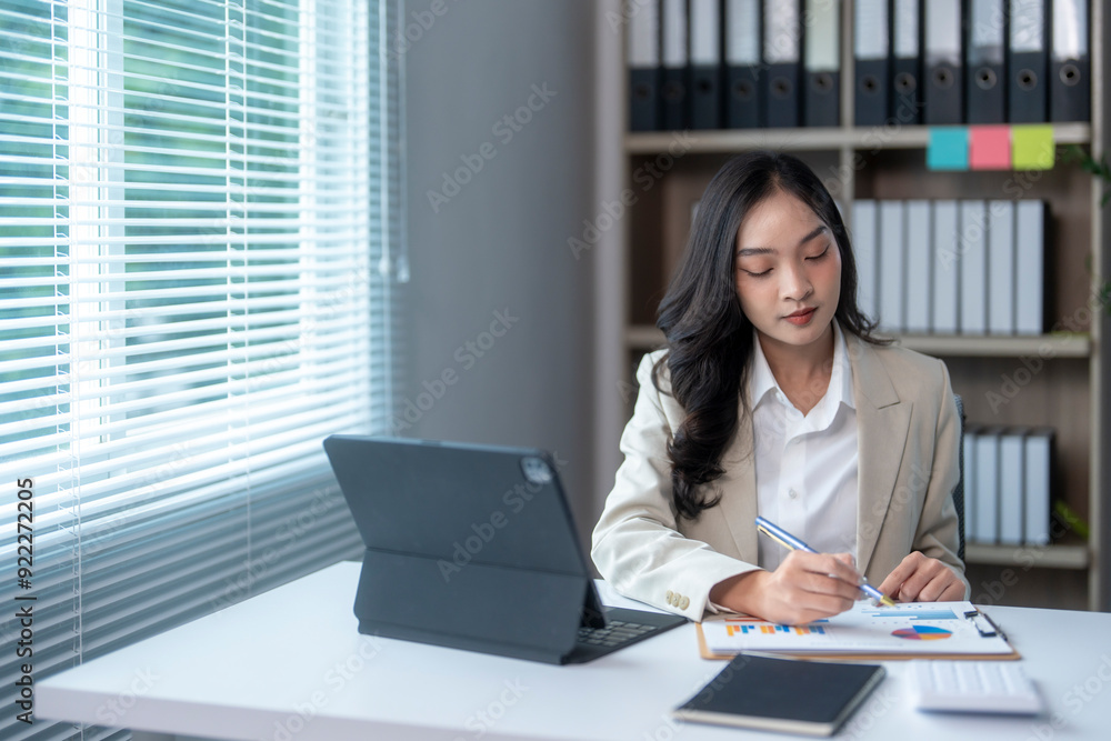 Asian businesswoman working with financial graph chart at office Asian businesswoman working with financial graph chart at office
