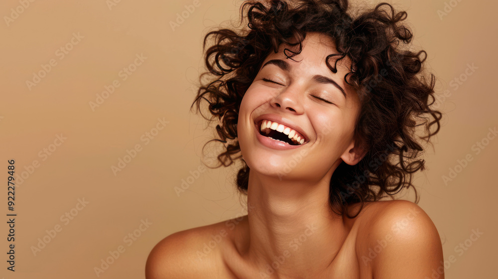 Portrait of a carefree laughing woman enjoying a spa treatment, bare shoulders, on a beige background Portrait of a carefree laughing woman enjoying a spa treatment, bare shoulders, on a beige background