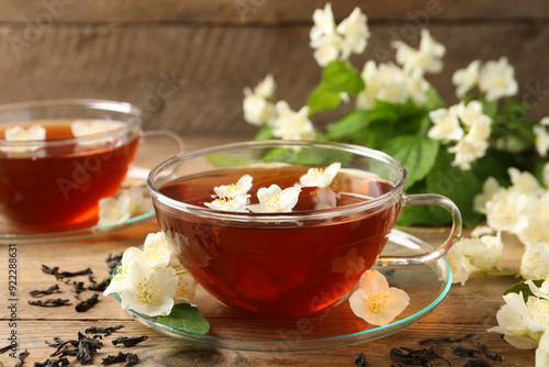 Hot jasmine tea in cups and flowers on wooden table