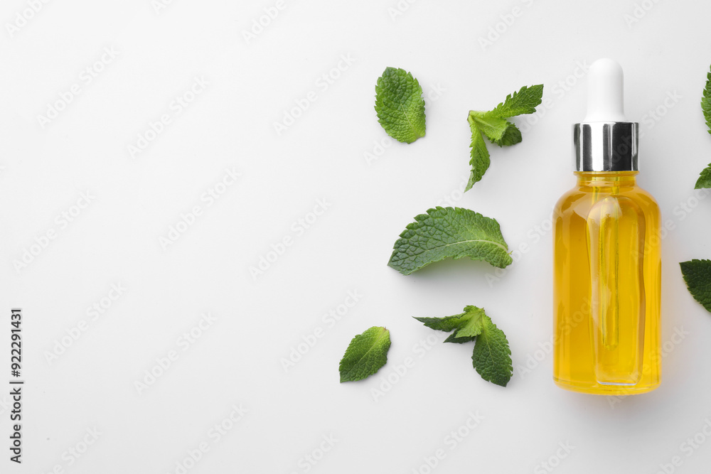 Bottle of essential oil and mint isolated on white, top view Bottle of essential oil and mint isolated on white, top view