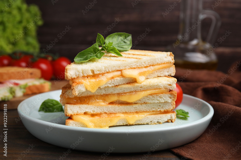 Pieces of toasted bread with melted cheese and basil on wooden table Pieces of toasted bread with melted cheese and basil on wooden table