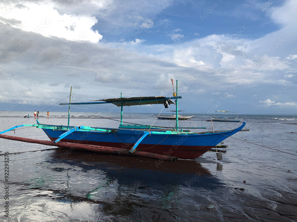 Beautiful view of a boat anchored by the sea on a bright, sunny, and cloudy day. Beautiful view of a boat anchored by the sea on a bright, sunny, and cloudy day.
