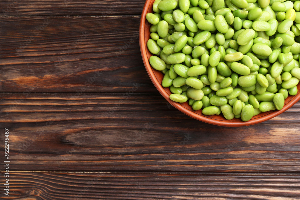 Raw green edamame soybeans in bowl on wooden table, top view. Space for text Raw green edamame soybeans in bowl on wooden table, top view. Space for text