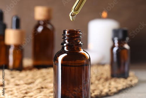 Wallpaper Mural Essential oil dripping from pipette into bottle at table, closeup Torontodigital.ca