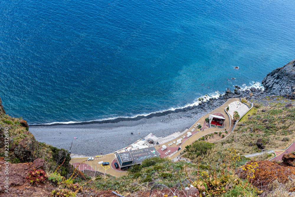 Cristo Rei. Jesus monument on top of a cliff overlooking the Atlantic Ocean and a cable car leading down to the beach on the island of Madeira