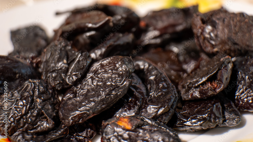 A plate of dried fruit with a black color A plate of dried fruit with a black color