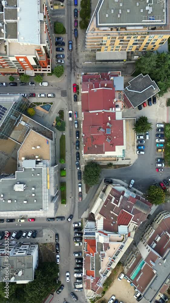 Drone video of an urban neighborhood, showcasing a top-down view of residential buildings, streets, and parked cars. The footage highlights the organized layout and bustling city life Drone video of an urban neighborhood, showcasing a top-down view of residential buildings, streets, and parked cars. The footage highlights the organized layout and bustling city life