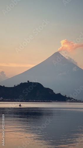 Mayon volcano with a fishing man fishing boat sunset sunrise golden hour in Legazpi City Albay Bicol Philippines  photo