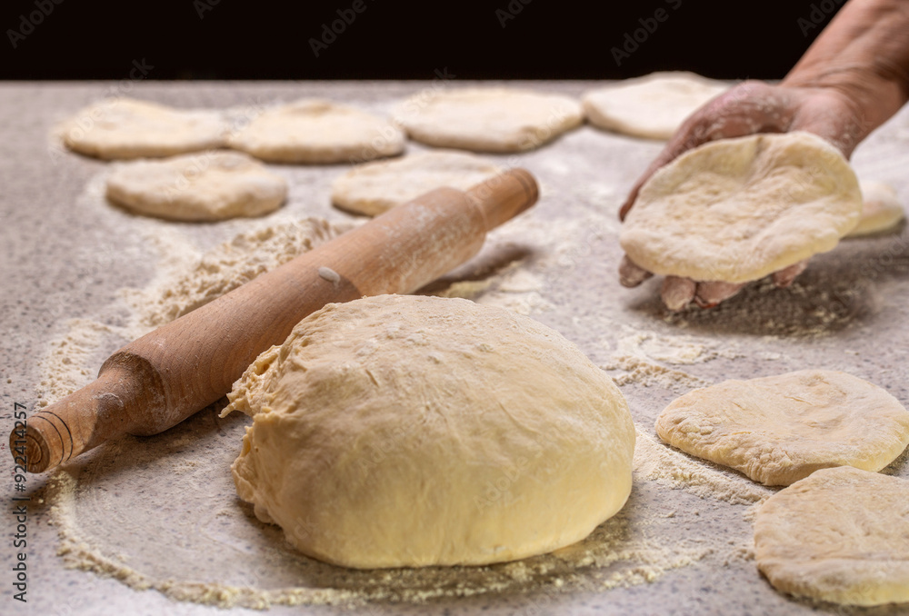 Process of making pies. Baking at home. Homemade cakes dough in the women's hands. Woman rolling out dough on kitchen table, close up. Hands baking dough with rolling pin on wooden table Process of making pies. Baking at home. Homemade cakes dough in the women's hands. Woman rolling out dough on kitchen table, close up. Hands baking dough with rolling pin on wooden table