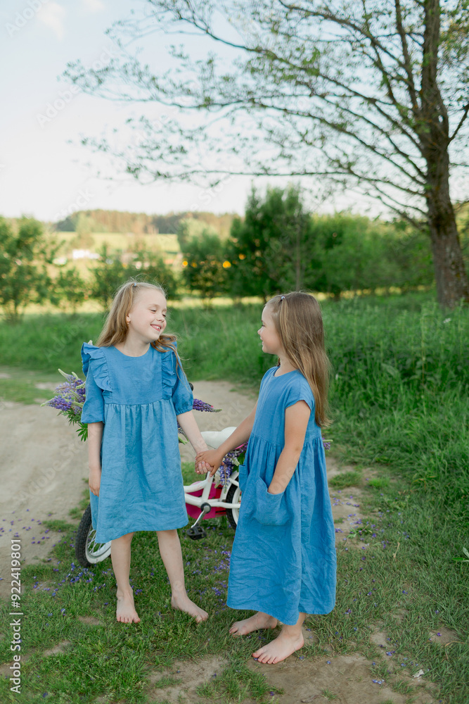Obraz premium two sisters with bicycle and flowers