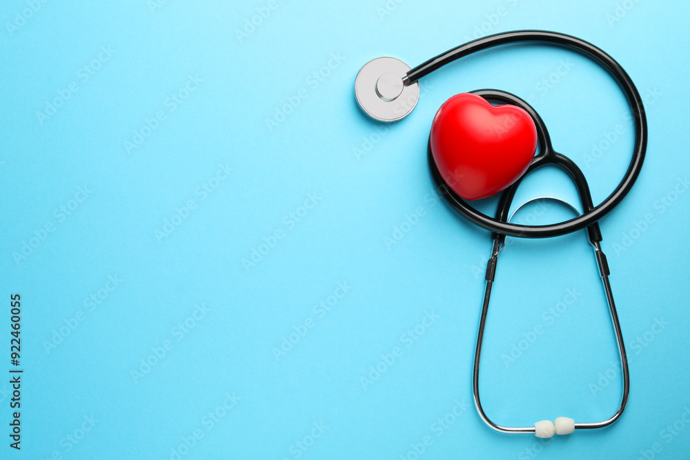 Stethoscope and red heart on light blue background, top view. Space for text Stethoscope and red heart on light blue background, top view. Space for text