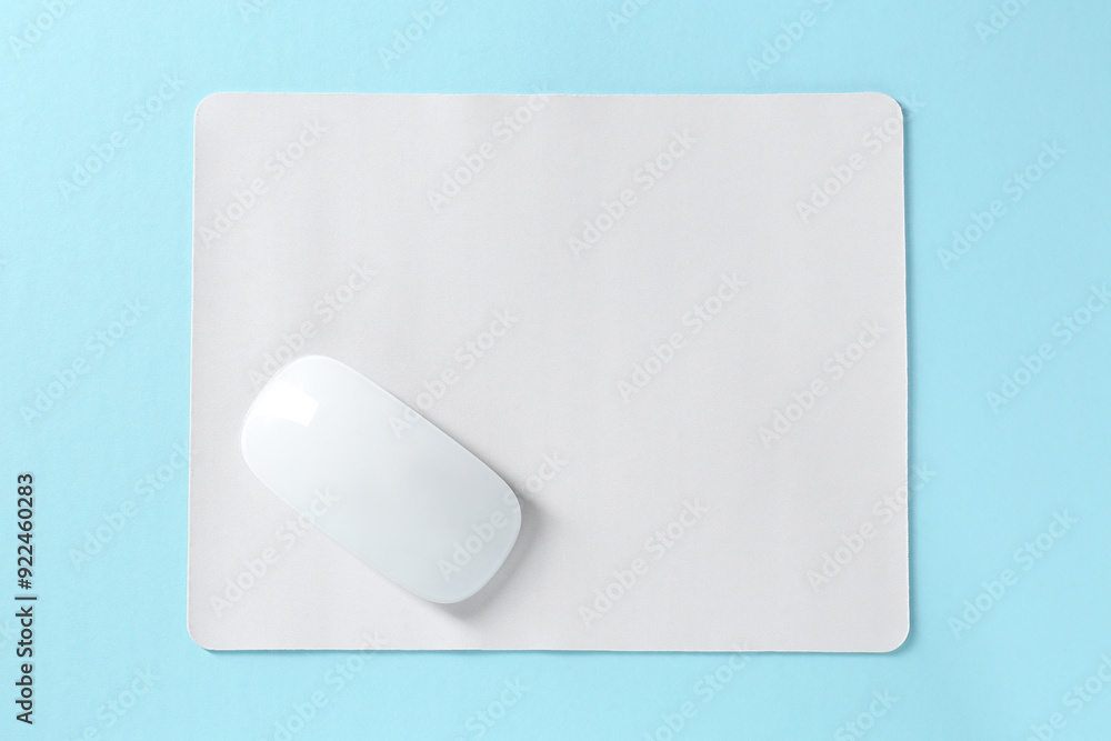 Wireless mouse and mousepad on light blue background, top view Wireless mouse and mousepad on light blue background, top view
