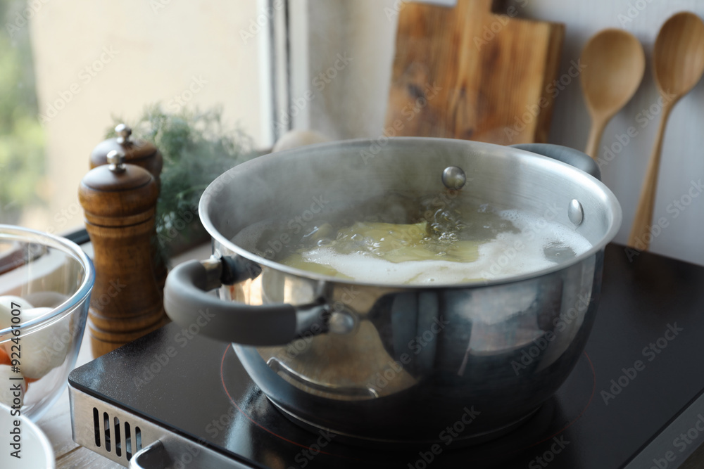 Boiling potatoes in pot on stove in kitchen Boiling potatoes in pot on stove in kitchen