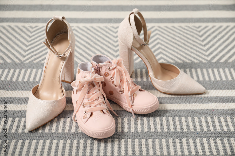 Naklejka premium Big and small shoes on carpet indoors