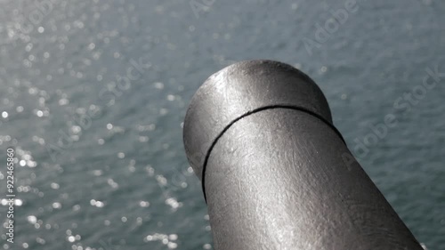close up pirate cannon under the deck of an 18th century sailing ship with the hatch open facing the sea