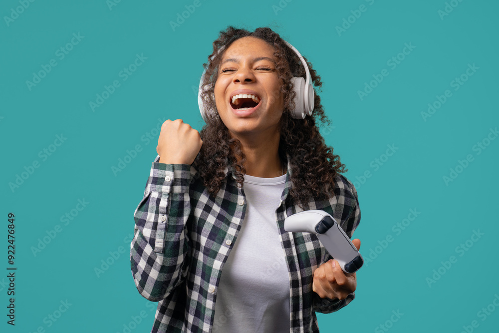 Teenager african girl playing and wins online video game on console with joystick Teenager african girl playing and wins online video game on console with joystick