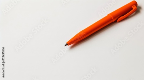 Bright orange pen placed diagonally on a clean white background