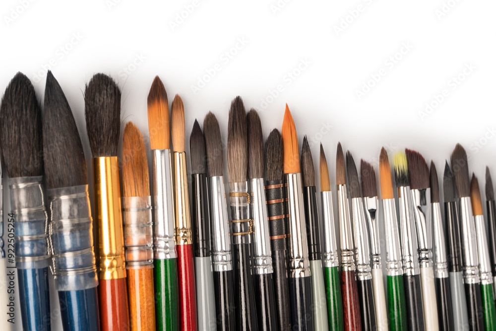 Mix of paint brushes in a row isolated on a white background. Mix of paint brushes in a row isolated on a white background.