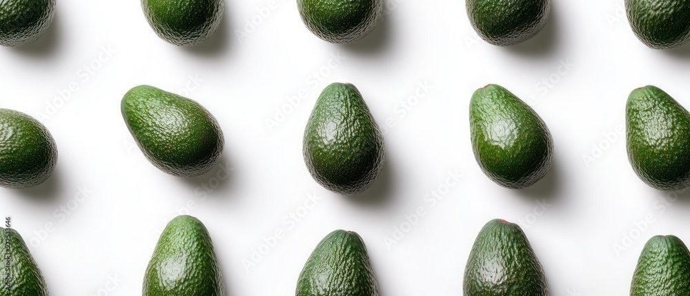Green Avocados in a Pattern on White Background Green Avocados in a Pattern on White Background