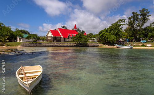 Exposure of on of the most renowned churches in Mauritius is the Notre Dame Auxiliatrice Chapel, a Roman Catholic Church famous for its vivid red roof against the bright turquoise sea and azure sky photo