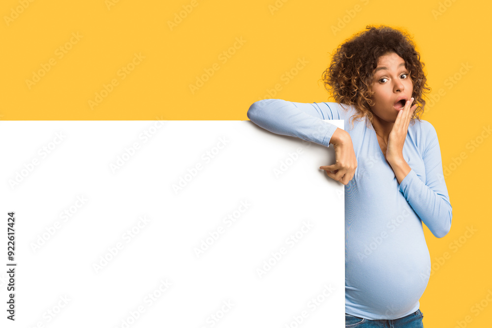 Amazing offer. Shocked expectant woman near blank white poster, mockup, free space Amazing offer. Shocked expectant woman near blank white poster, mockup, free space