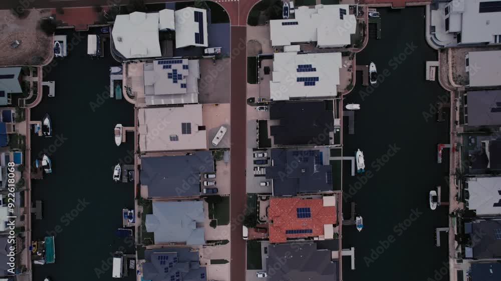 This aerial perspective showcases a row of homes lining a canal, with various boats docked along the waterways under a clear sky. This aerial perspective showcases a row of homes lining a canal, with various boats docked along the waterways under a clear sky.