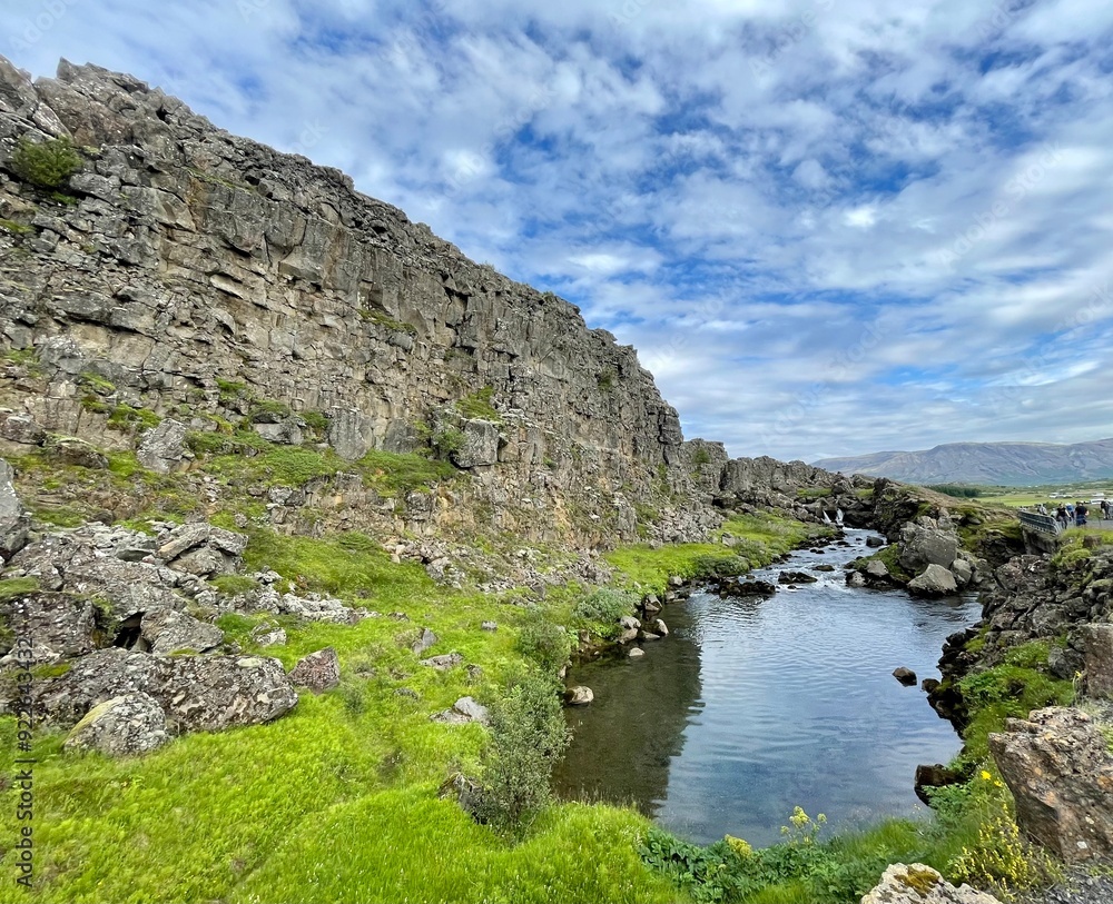 Fototapeta premium A captivating image of a serene river flowing through the rugged terrain of Thingvellir National Park in Iceland. 