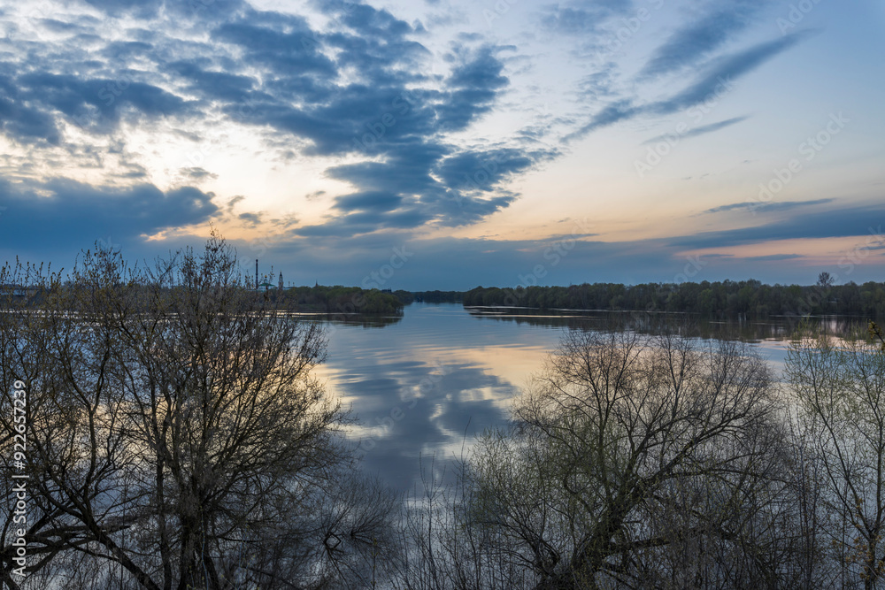Golden hues reflect on calm waters as the sun sets behind distant trees, creating a peaceful atmosphere for evening contemplation. Golden hues reflect on calm waters as the sun sets behind distant trees, creating a peaceful atmosphere for evening contemplation.