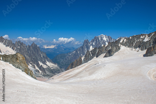 View from above of a large snowfield in the alps and a glacier covered with brown sahara sand  photo