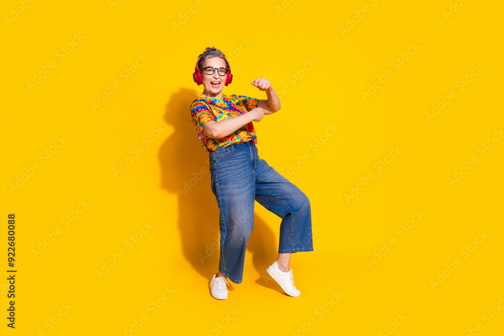 Full body portrait of nice aged lady dance headphones empty space wear t-shirt isolated on yellow color background Full body portrait of nice aged lady dance headphones empty space wear t-shirt isolated on yellow color background