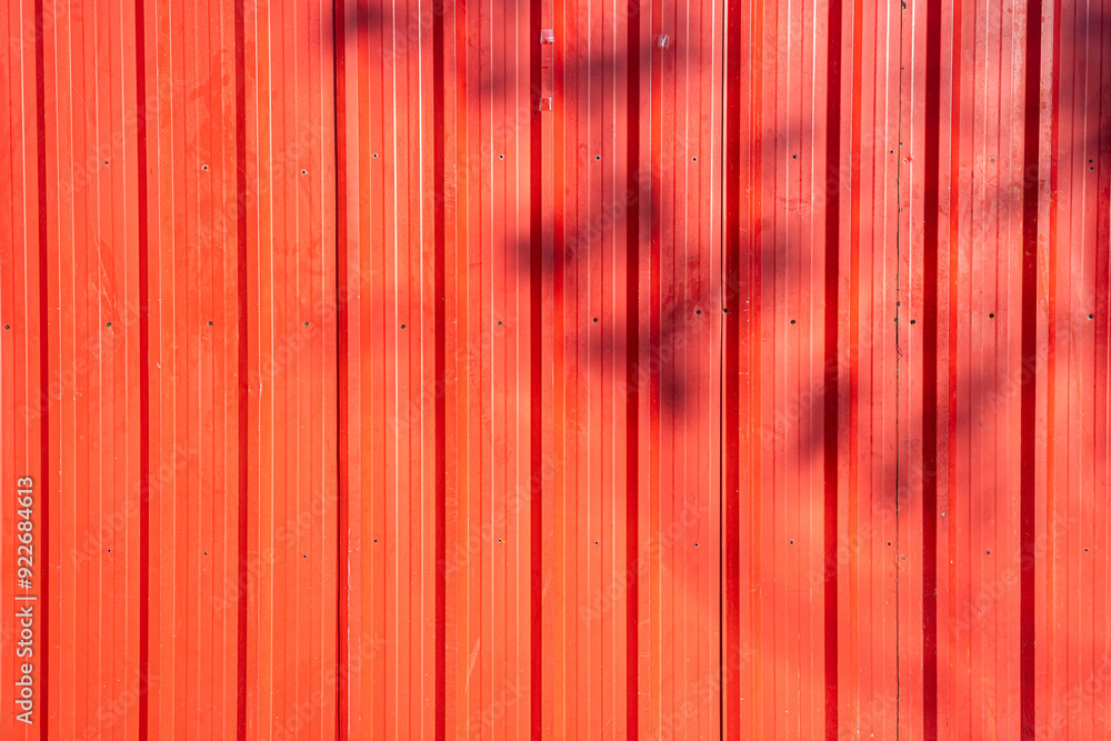 Red or orange old corrugated metal with Shadow of a branch texture surface sheet for industrial building background, copy space text or design