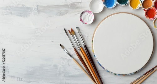 Colorful Art Supplies on a Table in a Studio With Paintings and Brushes